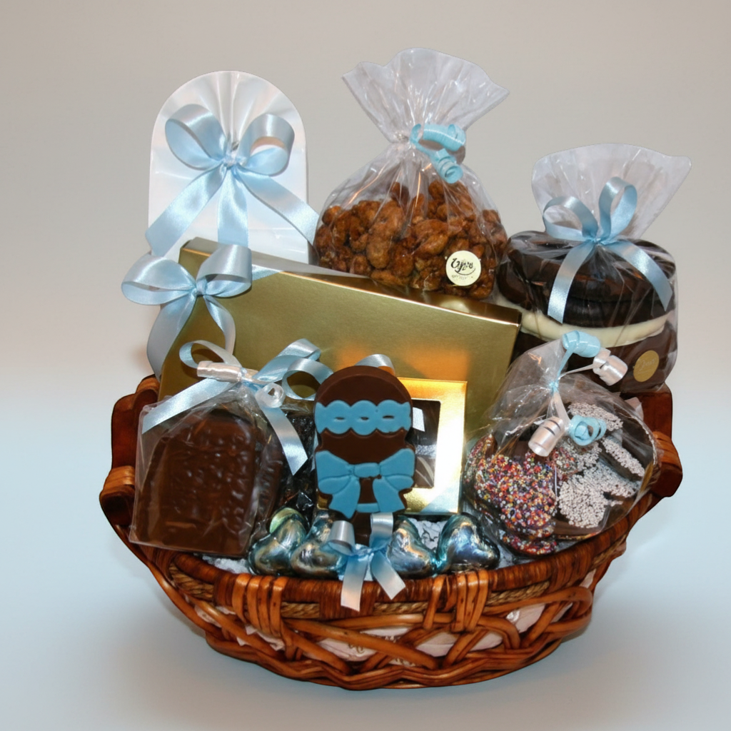 Enjou Chocolat baby gift basket with chocolates, cookies, nuts, and a chocolate rattle. Blue ribbons.