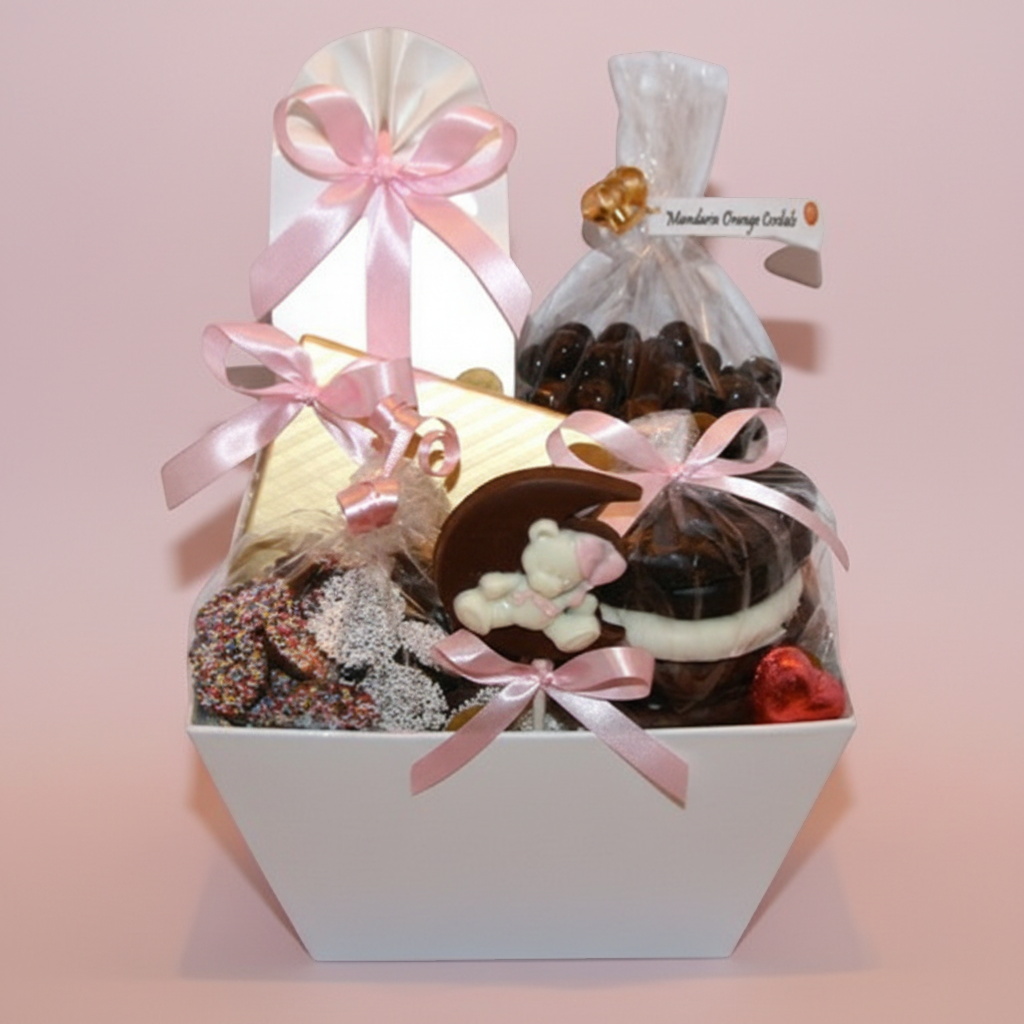 Enjou Chocolat baby gift basket with assorted chocolates, including a chocolate teddy bear on the moon and chocolate-covered Oreos, tied with pink ribbons.